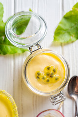 Passion fruit mousse on white wooden background, vertical composition