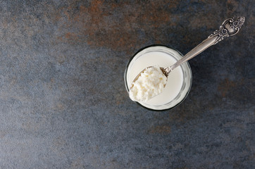 Fototapeta na wymiar Spoon with cottage cheese,glass with milky product