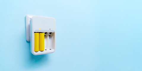 Photo of charger with two yellow batteries
