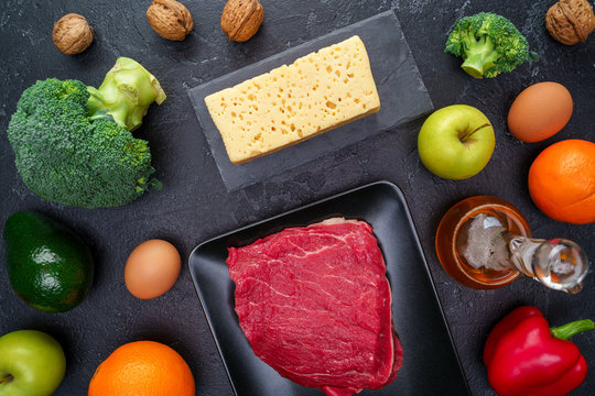 Image of products for diet, meat, apple, oil, avocado, cheese, orange on empty black background