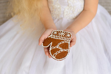 Gingerbread in the girl's hands in a white magnificent dress