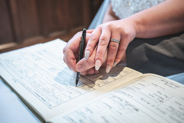A bride and groom signing a dummy register 