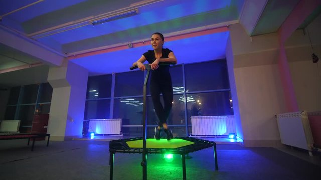 JUMPING FITNESS: A beautiful girl jumping on a fitness trampoline. Slender girl performs exercises on trampolines. Fitness exercises for a beautiful and slim figure