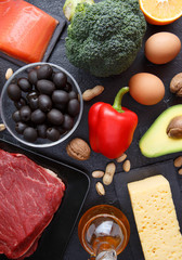 Photo of products for ketogenic diet on black stone table.