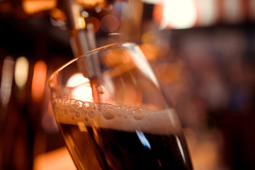 close-up of barman hand at beer tap pouring a draught lager beer