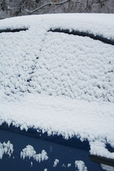 Car covered by snow in winter season. Side view in selective focus.