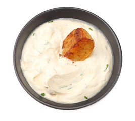 Fried potato wedges with garlic sauce in black bowl isolated on white background
