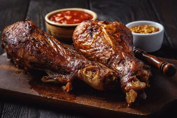 Photo sur Plexiglas Plats de repas Roasted turkey legs, on dark wooden background.