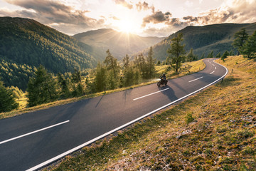 Fototapeta premium Kierowca motocykla jedzie w alpejską drogę