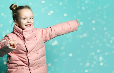 small attractive girl in a jacket down jacket has fun in the room.