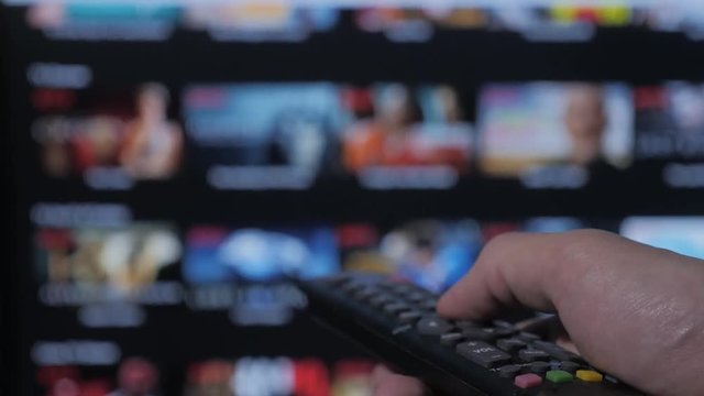 smart tv. online video streaming service. with apps and hand. Male hand holding remote the control turn off smart tv . man hand controls holding remote lifestyle . concept internet online cinema