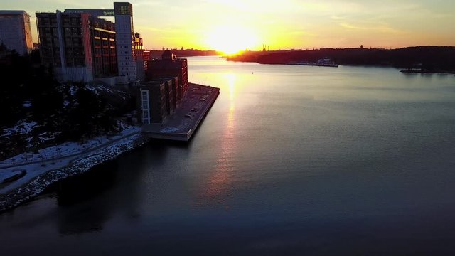 Drone flyby towards Kvarnholmen Stockholm over water at sunset 1