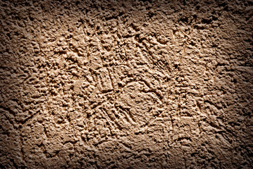 Grunge texture, rough ragged dark background, brown plaster stucco wall.
