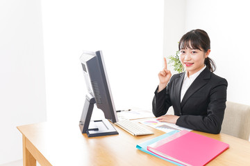スーツ姿で指をさす若い女性