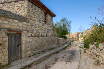 Fototapeta na wymiar Old street. Old houses with tiled roofs. Chufut Kale, a cave city in Crimea from the 5th century