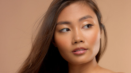 Fototapeta premium closeup portrait of asian thai japanese model wathing aside with hair blowing