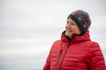 Happy mature woman outdoors on a cold day, taken with copy space 