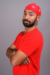Portrait of young handsome Indian man wearing red shirt