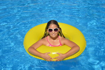 Real adorable girl relaxing in swimming pool