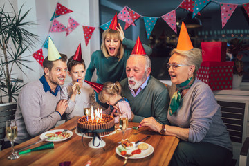 Family celebrating grandfather's birthday together © Mediteraneo
