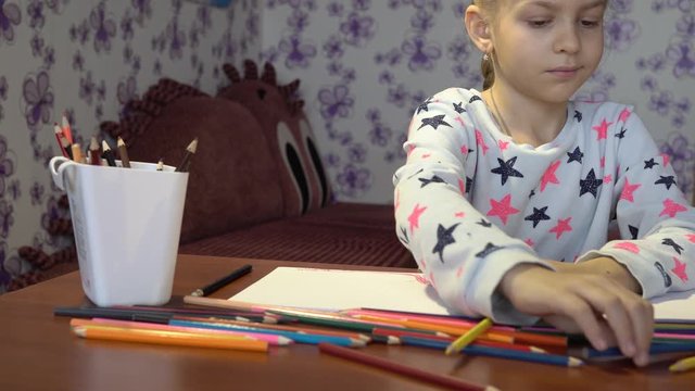 Creative baby. Portrait of a little cute girl who draws with colored pencils