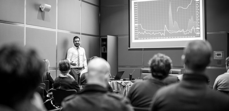 Public Speaker Giving a Talk at Business Meeting. Audience in the conference hall. Business and Entrepreneurship concept. Black and white image.