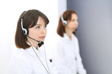 Call center. Group of operators at work. Focus on young brunette woman. Business  concept