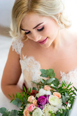 Naklejka premium The morning of a beautiful bride dressed in a peignoir surrounded by flowers.