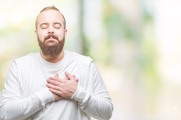Naklejka na ściany i meble Young caucasian hipster man wearing sport clothes over isolated background smiling with hands on chest with closed eyes and grateful gesture on face. Health concept.