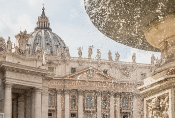 Basilica of St. Peter and fountains in Vatican, Roma, Italy.Particular of dome of Basilica with statues.