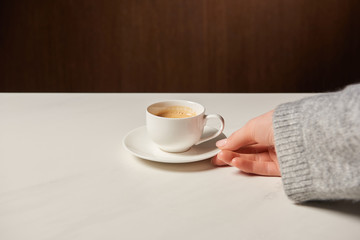 cropped view of woman holding cup with hot coffee