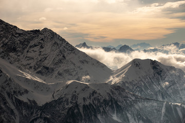 Fantastic dreamy sunrise on top of rocky mountain with view into misty valley. Foggy mountain. Sunset clouds. Misty peaks. Foggy landscape. Top of High mountains, covered by snow.