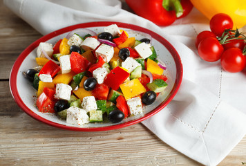 Greek salad with tomatoes cherry on the wooden table.