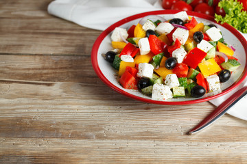 Greek salad with tomatoes cherry on the wooden table.
