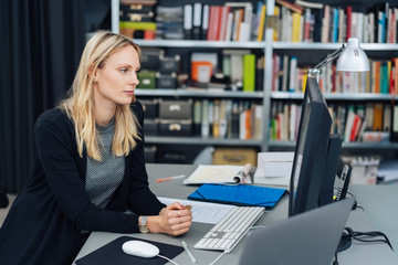 Young woman sitting working at a desktop computer