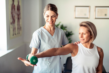 A Modern rehabilitation physiotherapy worker with woman client