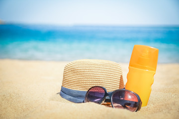 Stylish beautiful hat with cream on the seashore background