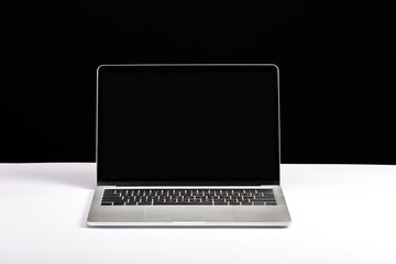 laptop with blank screen on white desk isolated on black