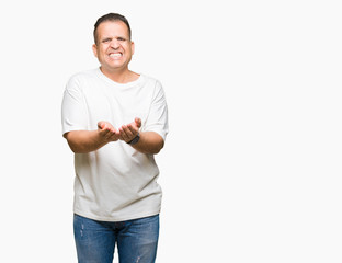 Middle age arab man wearig white t-shirt over isolated background Smiling with hands palms together receiving or giving gesture. Hold and protection