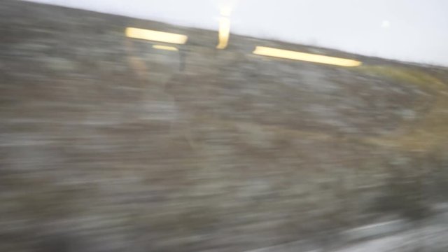 Cinematic defocused view through the window of a fast TGV ICE train over the French hills and villages early in the morning on the cold snowy winter - 4K UHD footage