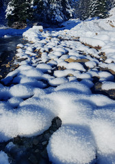 Beautiful winter landscape. Frozen river and rocky river bank covered with snow.