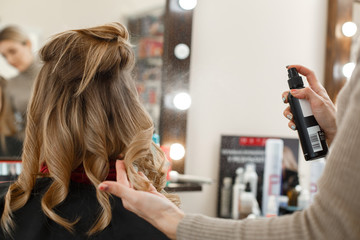 process of hair styling in the hairdressing salon.
Professional hairdresser working with client in salon
Hairstyle master makes an evening hairstyle
flat hair in the hands of hairdresser
