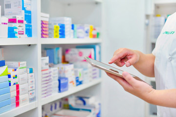 Pharmacist holding computer tablet Using for filling prescription in pharmacy drugstore  - obrazy, fototapety, plakaty