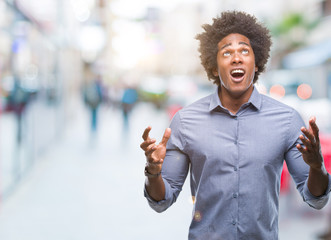 Afro american man over isolated background crazy and mad shouting and yelling with aggressive expression and arms raised. Frustration concept.