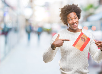 Afro american man flag of Spain over isolated background very happy pointing with hand and finger