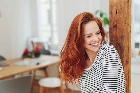 Laughing carefree young woman indoors at home