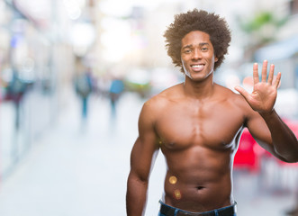 Fototapeta na wymiar Afro american shirtless man showing nude body over isolated background showing and pointing up with fingers number five while smiling confident and happy.