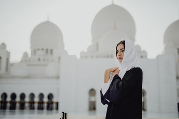 Beautiful young woman in Arabic clothes at Sheikh Zayed Grand Mosque in Abu Dhabi.