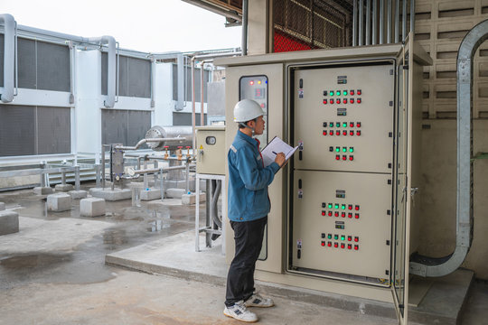 Young Engineer Checking Temperature Of Refrigeration And Setting Temperature Of Compressor At Control Switchboard Panel For Test Cool Down Of Cold Storage Room In The Factory