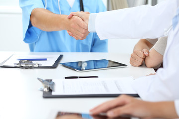 Doctors shaking hands to each other finishing up medical meeting